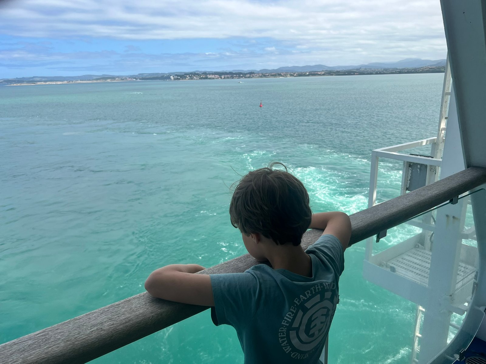 A child at the railing of the Pont-Aven watching the Spanish coastline come into view